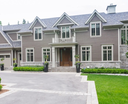 Traditional house with horizontal siding, 3 car garage and gables.