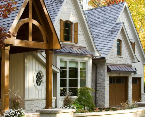 Traditional home with wood portico, natural stone and vertical siding.