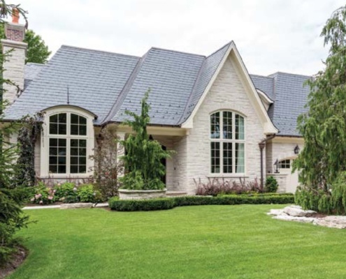 Traditional home with light stone, arched windows and white trim.