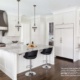 Custom kitchen with granite countertops, white cabinets and hardwood floor.