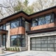 Natural modern home with corner windows, frosted glass garage door and landscape wall.