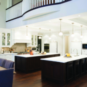 Traditional kitchen with breakfast bar, white countertop and tile backsplash.