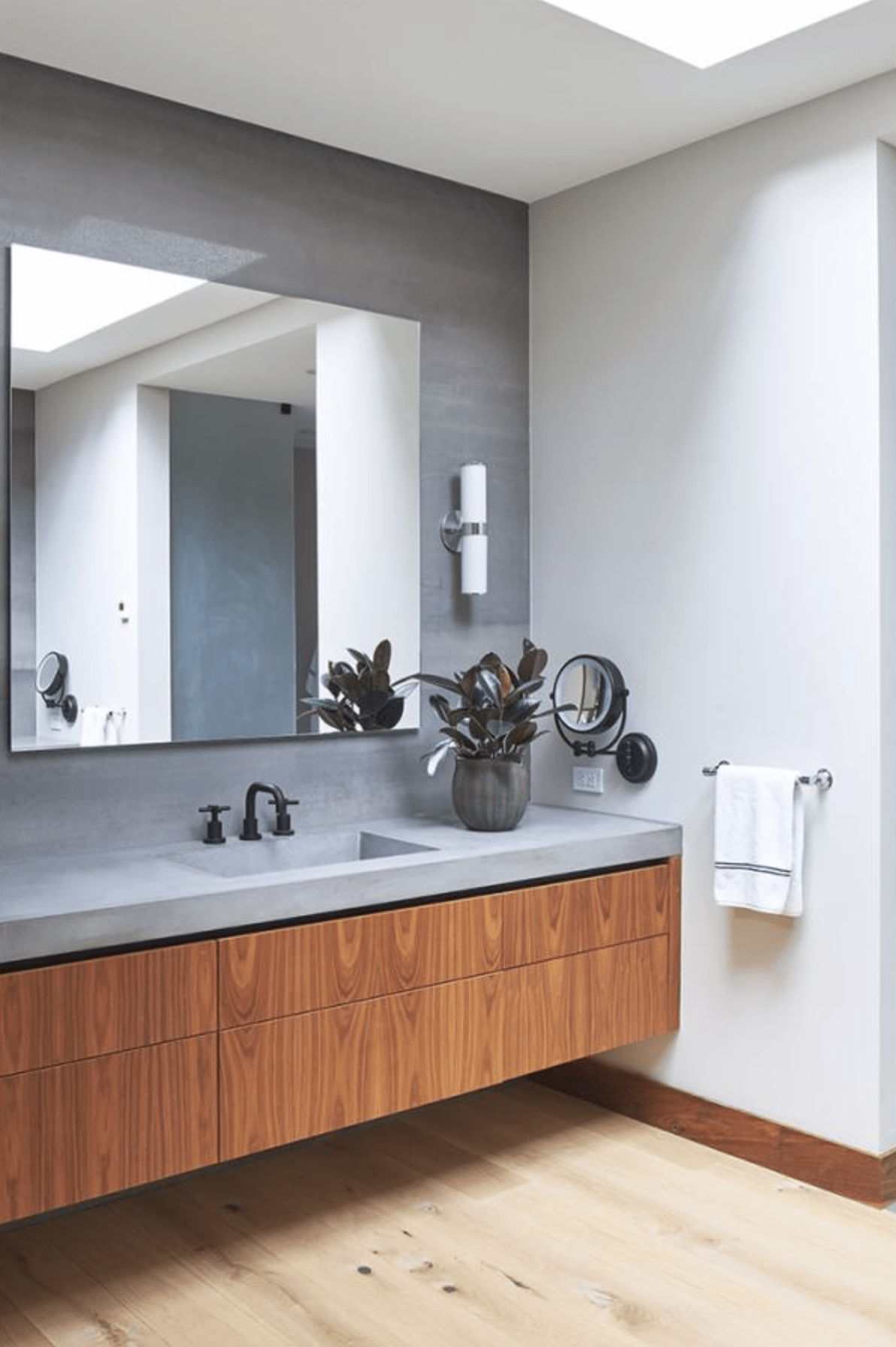 Contemporary bathroom with floating vanity, concrete countertop and wood floor.