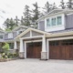 House renovation with wood siding, large eaves and tapered columns.