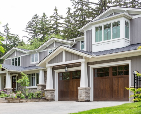 Mississauga renovation with wood garage door, white frame windows and stone skirt.
