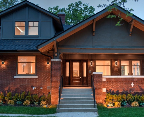 Toronto custom home with covered front porch, gabled roof and brick chimney.
