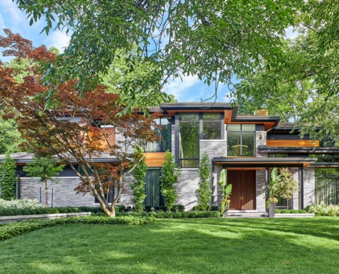 Oakville house with covered entry, modern stone and light wood siding.