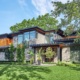 Natural modern house with wood siding, flat roof black windows.