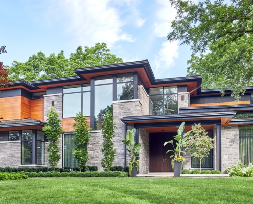 Modern house exterior with floating roof, stone column and corner window.