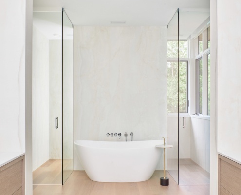 Contemporary bathroom with hardwood floor, white tile and corner windows.
