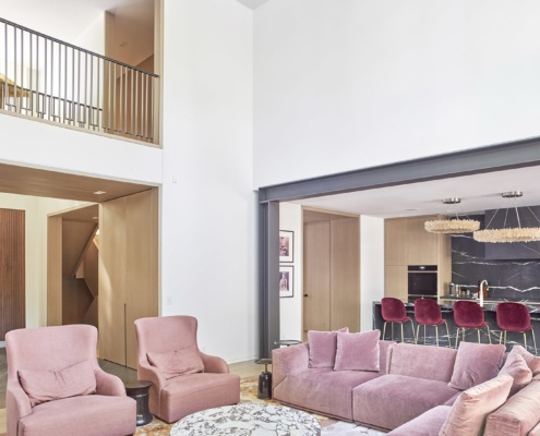 Modern family room with steel beams, white trim and wood ceiling.