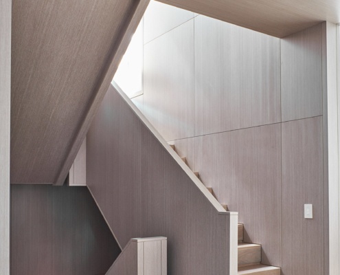 Modern wood staircase with hardwood floor and wood walls.