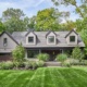 Traditional house with gabled roof, stucco siding and black trim.