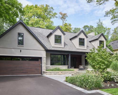 Transitional home with gables, black frame window and natural stone.