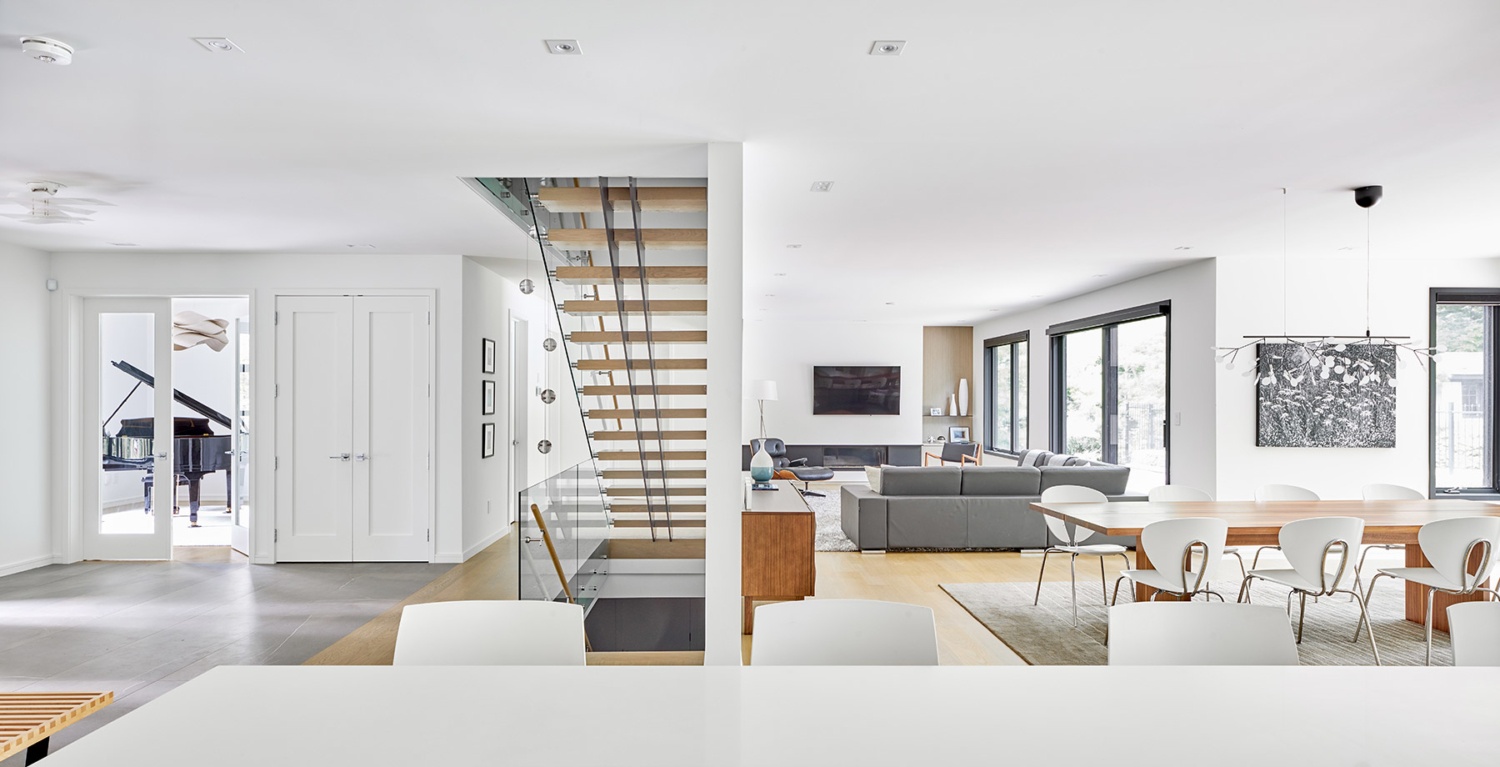 Modern custom home with floating staircase, hardwood floor and white trim.