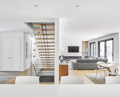 Modern custom home with floating staircase, hardwood floor and white trim.