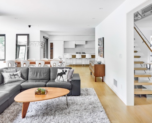 Contemporary living room with white baseboard, shag carpet and open concept.