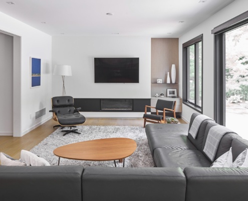 Modern living room with white baseboard, floor to ceiling window and built in shelf.