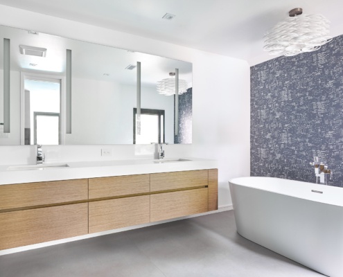 Modern bathroom with wallpaper, floating vanity and freestanding tub.