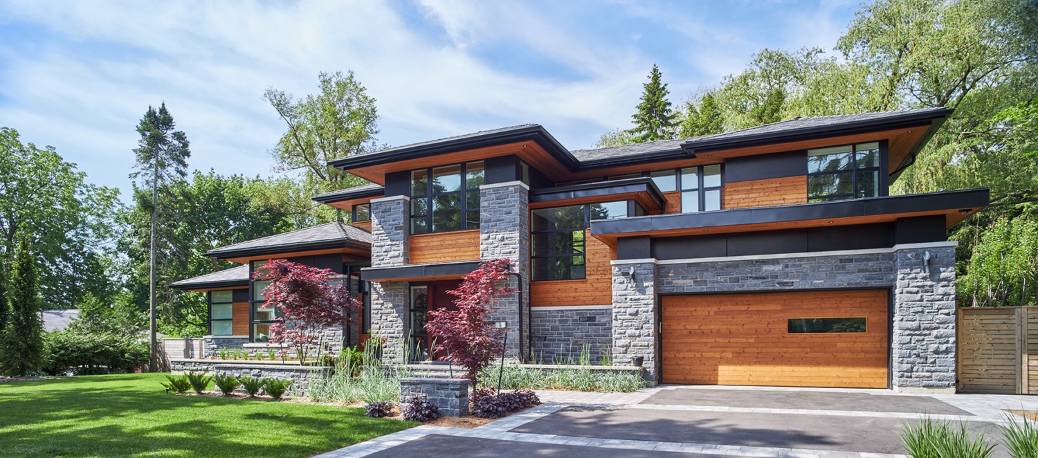 Natural modern house with wood garage door, wood soffit and natural stone siding.
