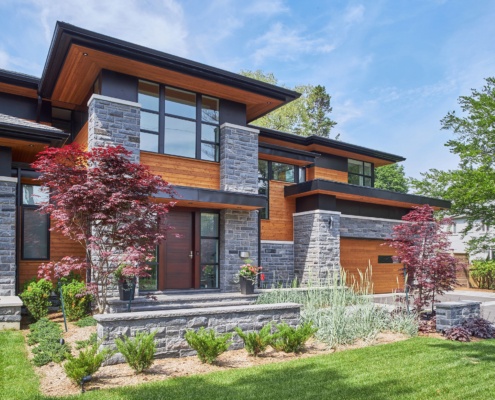 Contemporary house with metal cladding, wood front door and black cladding.