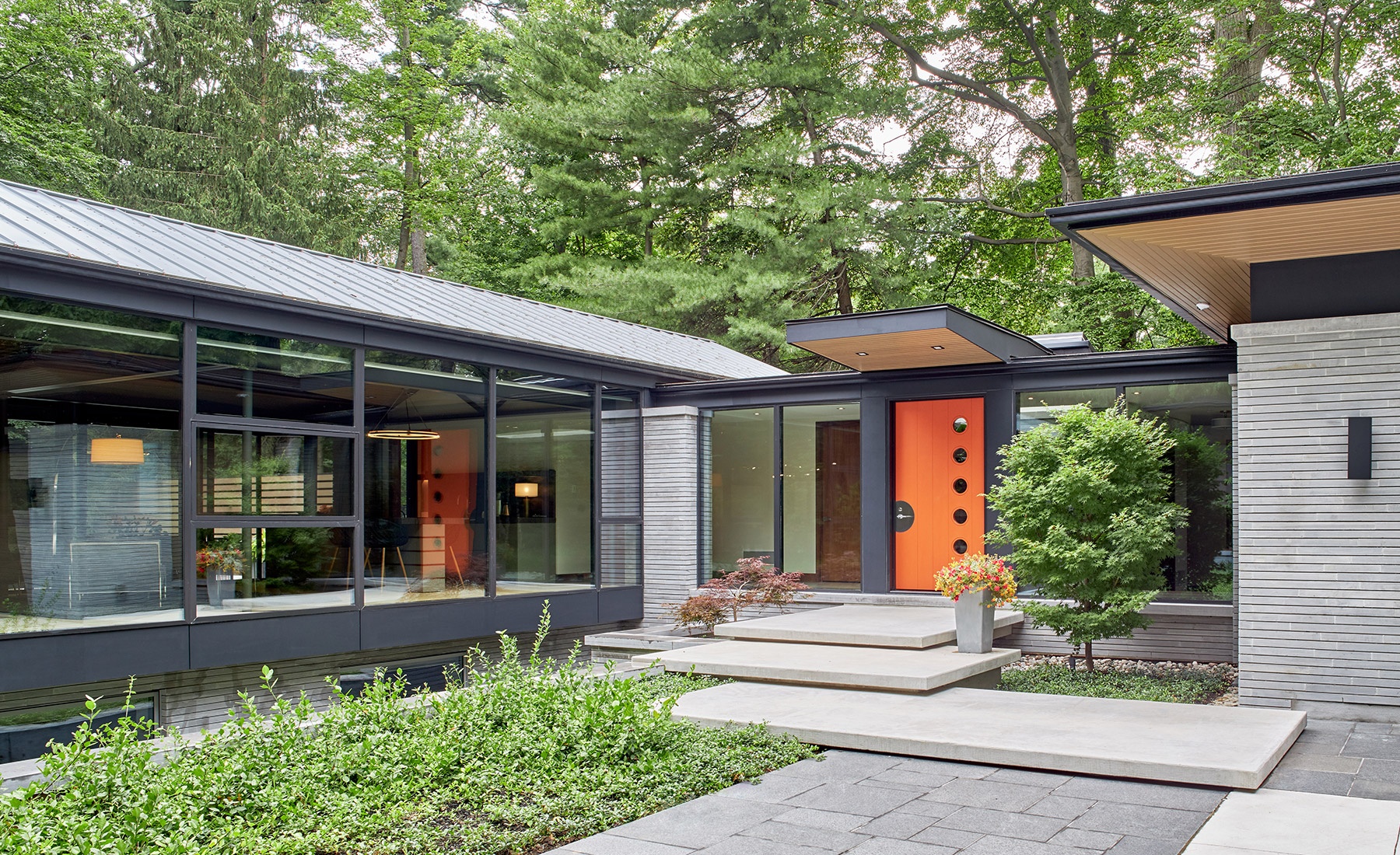 Mississauga bungalow with metal roof, concrete walkway and wood soffit.