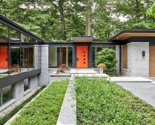 Modern home with black trim, large windows and inground planters.