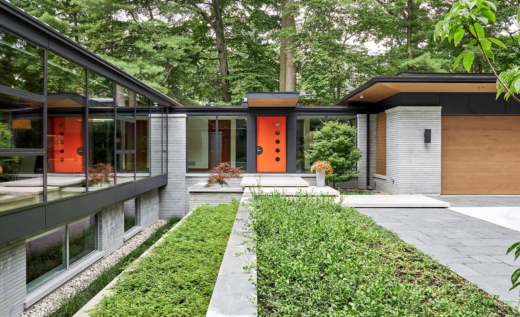 Modern home with black trim, large windows and inground planters.