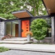 Covered entry with floor to ceiling window and stone siding.