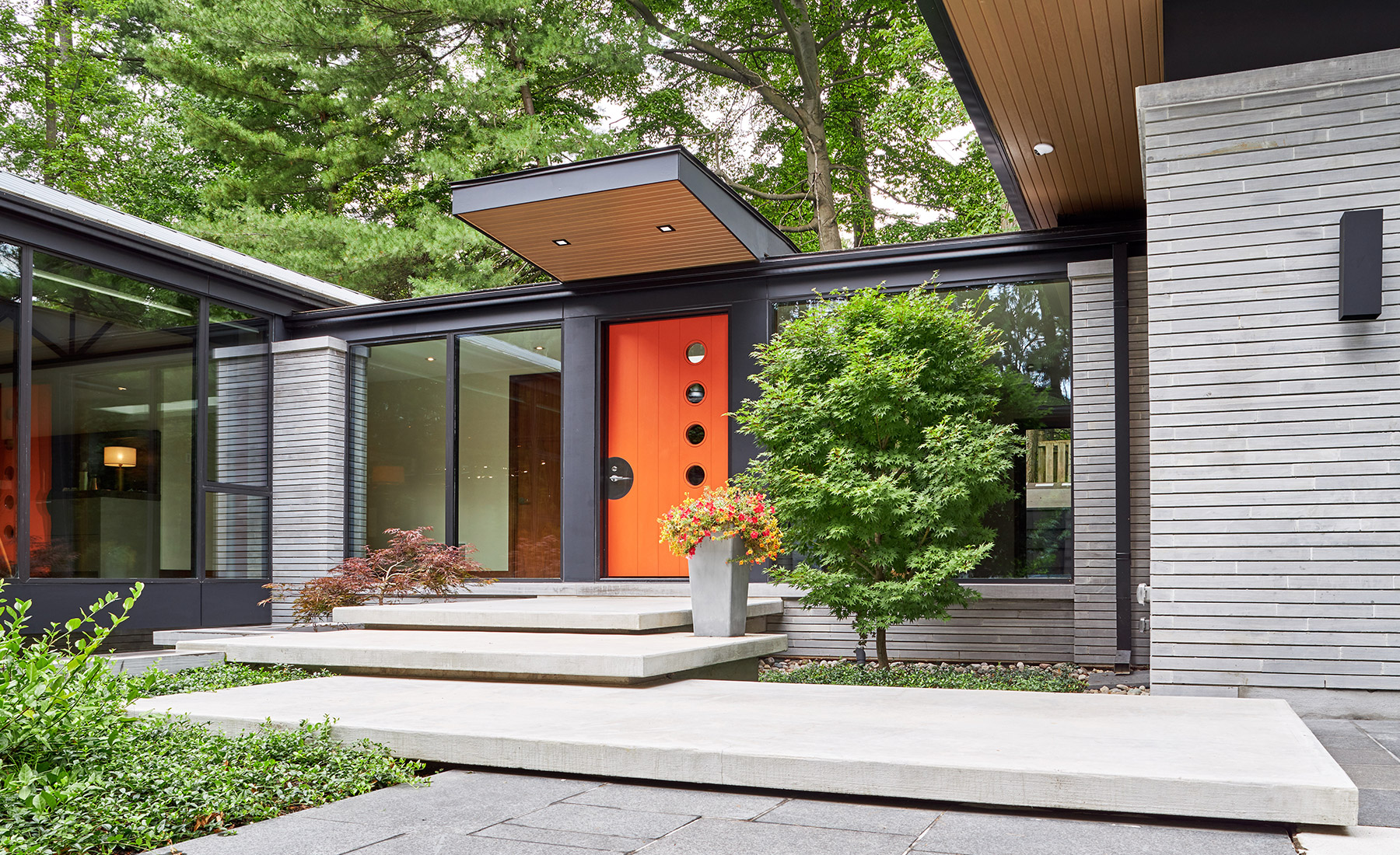 Covered entry with floor to ceiling window and stone siding.