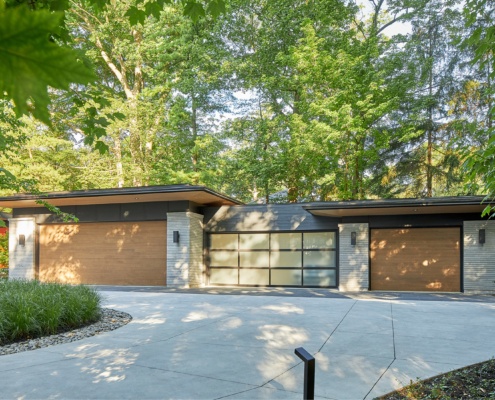 New garage with wood garage door, glass garage door and wood soffit.