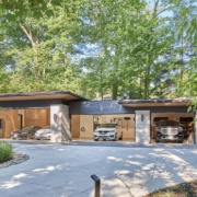 Modern 4 car garage with wood siding and stone columns.