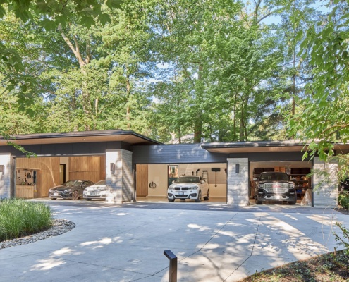 Modern 4 car garage with wood siding and stone columns.