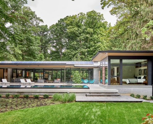 Modern home with solar panels, clean lines and stone siding.