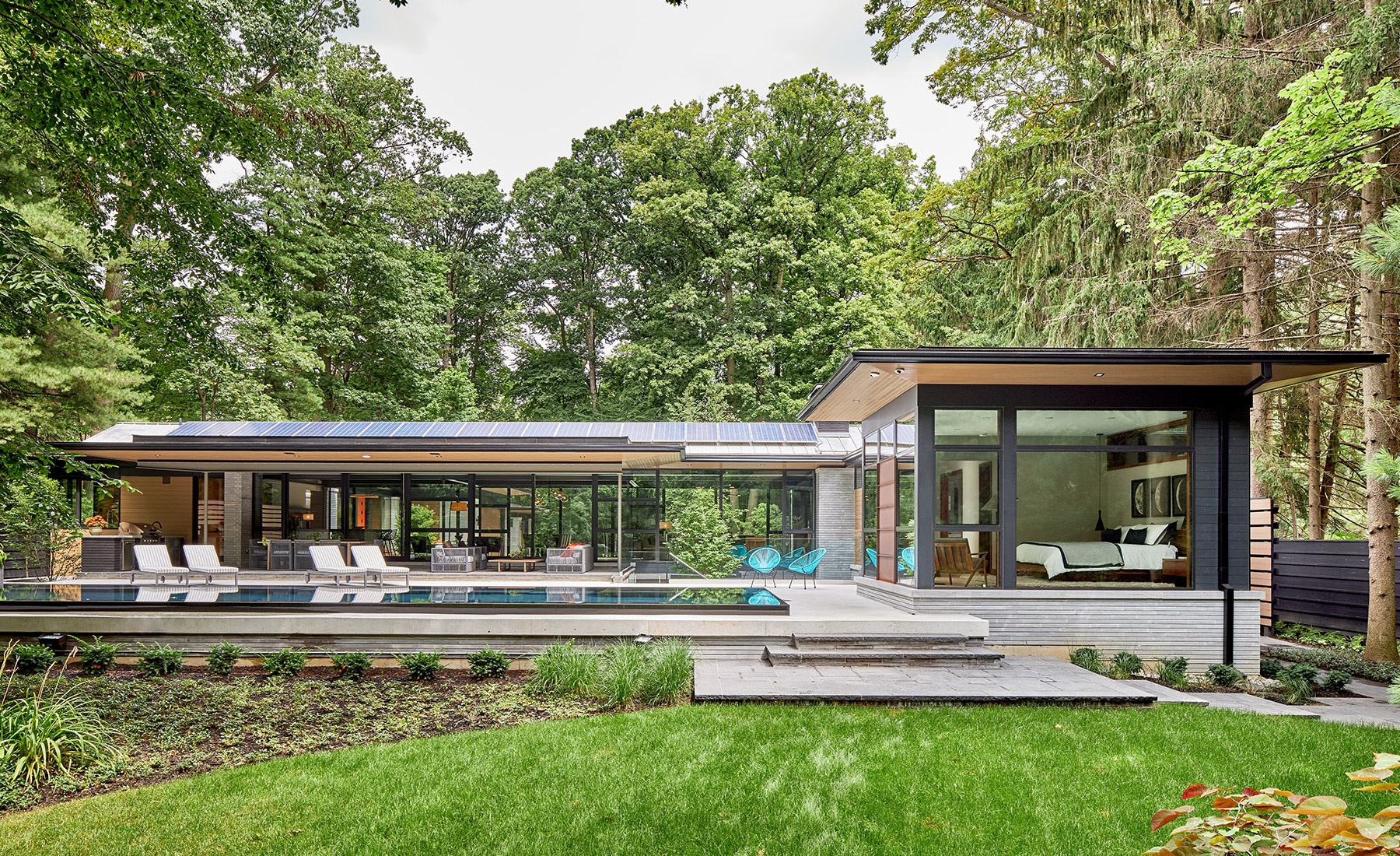 Modern home with solar panels, clean lines and stone siding.