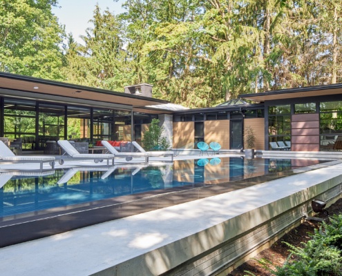 Mississauga house with floating roof, lap pool and black frame windows.