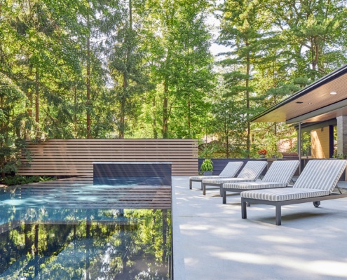 Contemporary backyard with brick wall, wood fence and wood soffit.