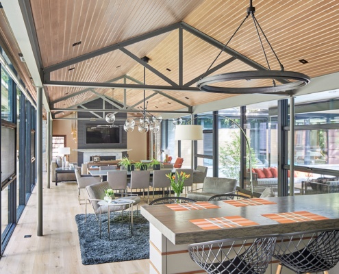 Open concept family room with hardwood floor, steel truss and floor to ceiling window.