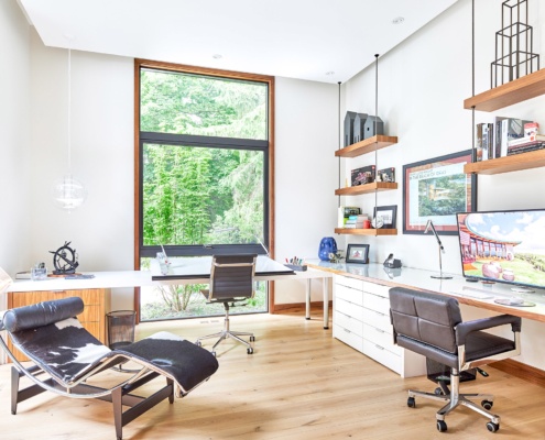 Home office with floor to ceiling window, floating shelf and built in desk.