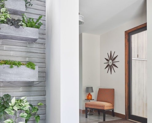 Front entry with stone wall, green wall and tile floor.