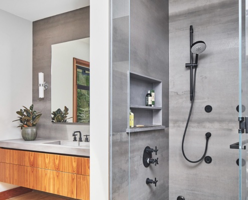 Bathroom with glass shower, floating vanity and hardwood floor.