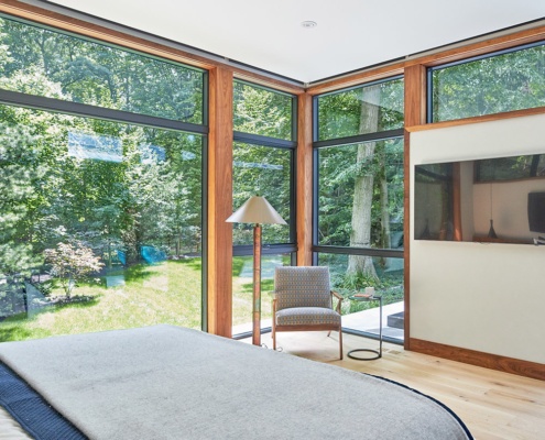 Modern master bedroom with large window, large frame window and wood baseboard.