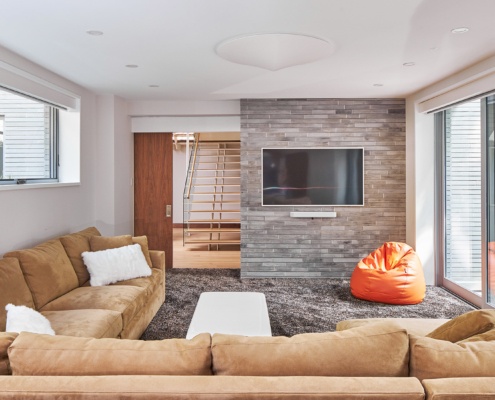 Family room with stone wall, l shaped coach and shag carpet.