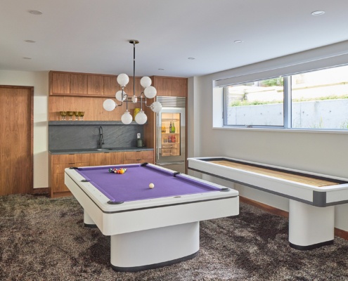 Modern basement with modern chandelier, stone backsplash  and baseboard
