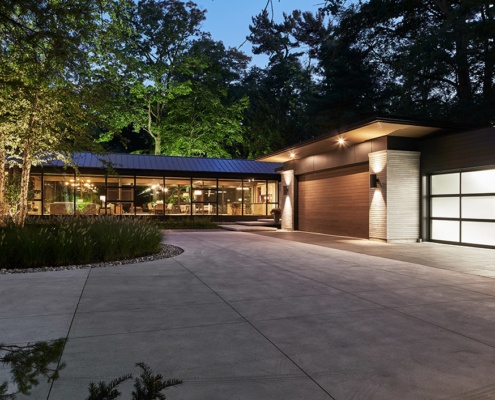 Custom home with metal cladding, metal roof and concrete driveway