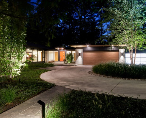 Large house with circular driveway, copper siding and 5 car garage.