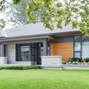 Modern bungalow with wood garage door, light stone and metal cladding.