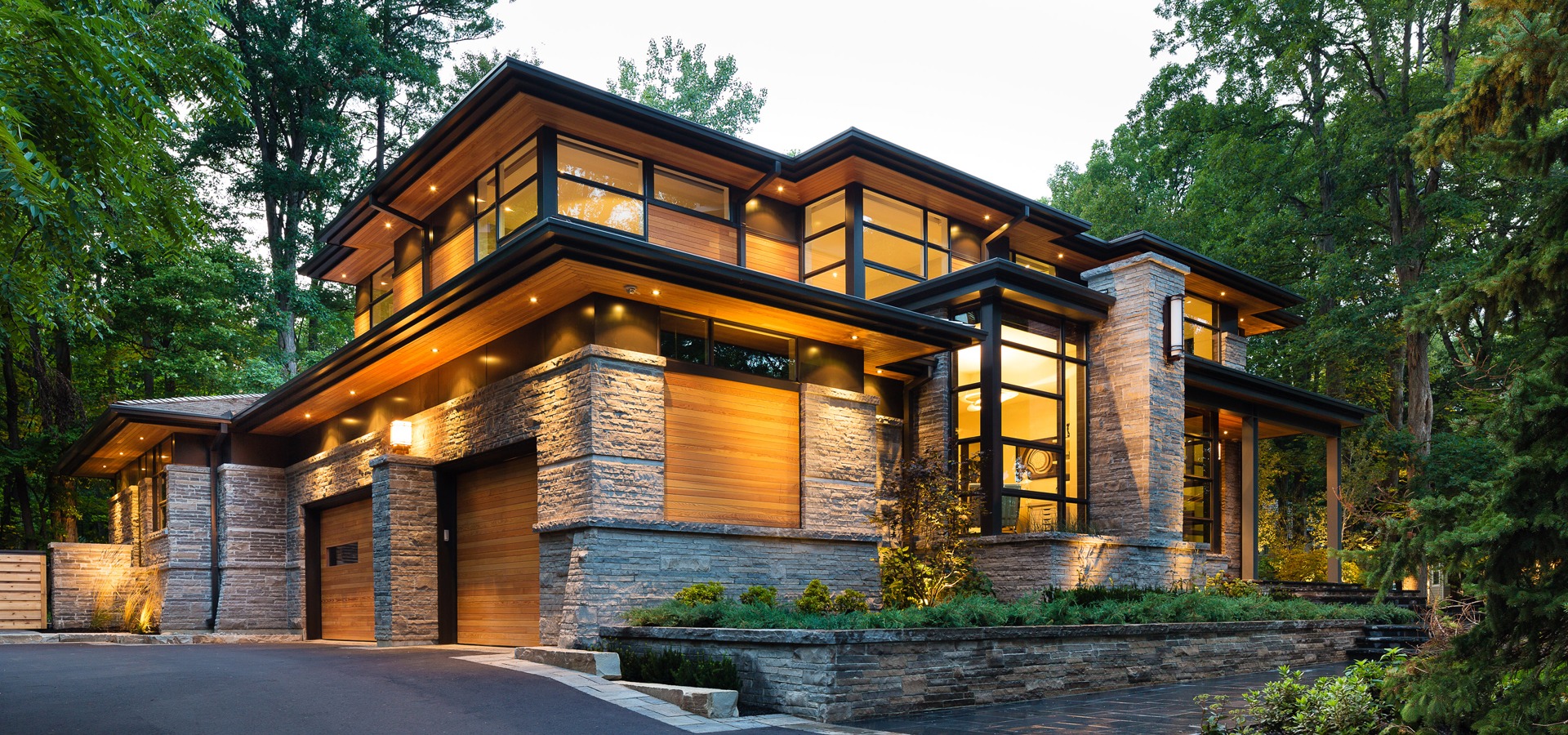 Natural modern house with wood siding, black frame windows and angled walls.