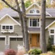 Custom home with white brackets, green garage door and grid windows.