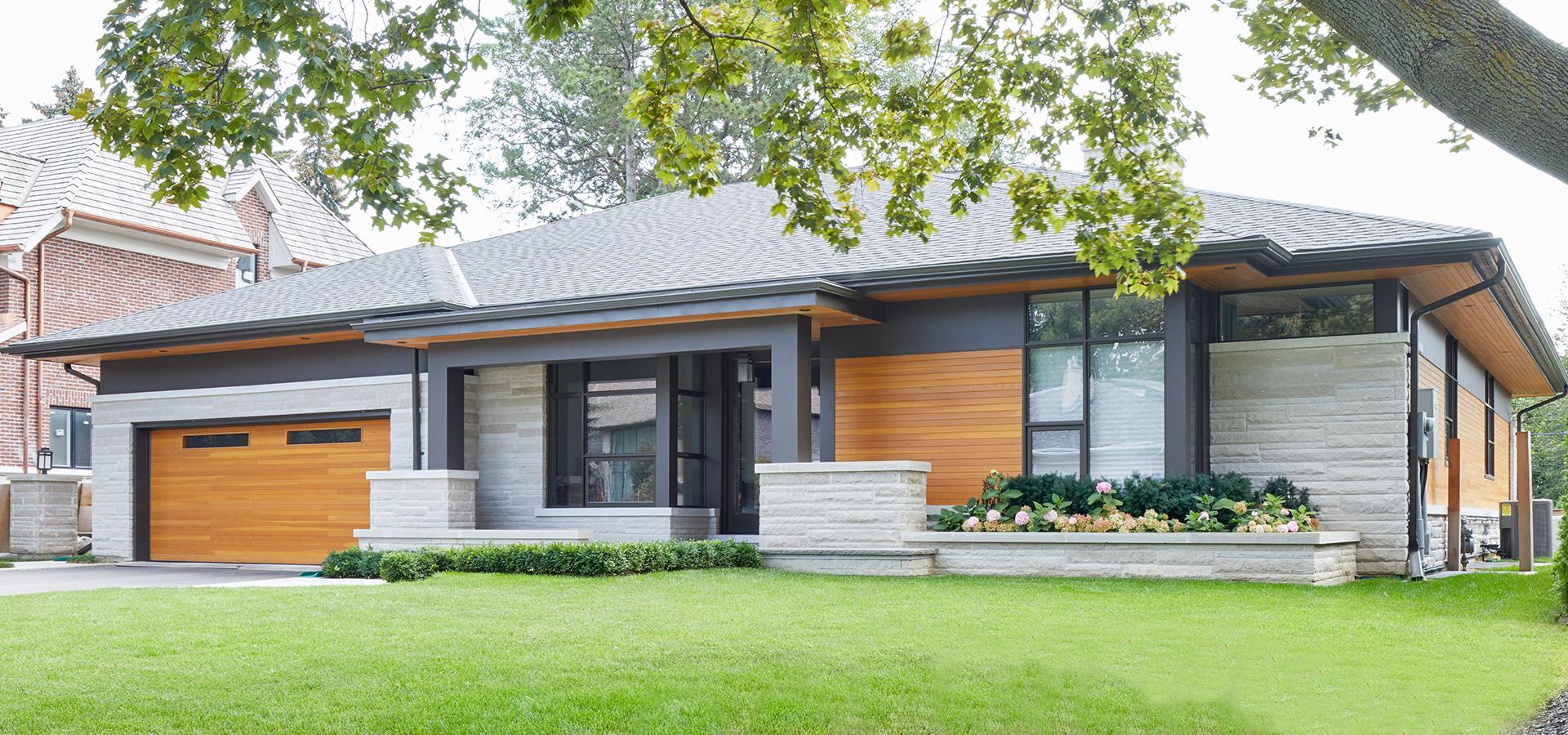 Modern bungalow with wood garage door, light stone and metal cladding.